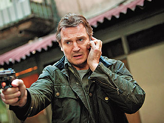 "You'll have to speak up; I'm holding a gun." Liam Neeson demonstrates two things you're not allowed to use on a plane.